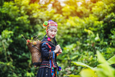 Portrait of smiling woman standing against plants