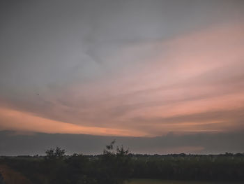 Scenic view of silhouette landscape against orange sky