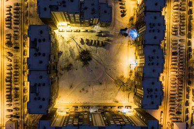 Drone view of illuminated buildings in city at night during winter