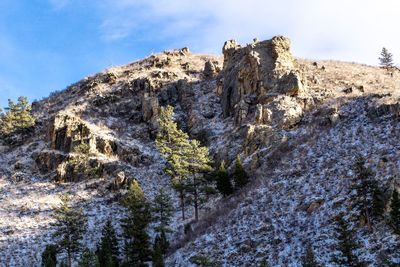 Low angle view of rocks on mountain against sky