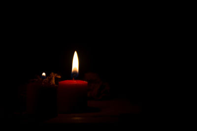 Close-up of burning candle in darkroom