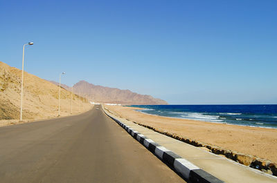 Scenic view of beach against clear blue sky