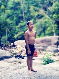 Portrait of shirtless boy standing on land