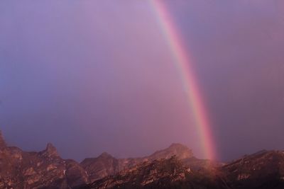 Low angle view of rainbow over mountains against sky