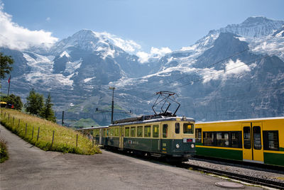 Train on railroad track by mountains against sky