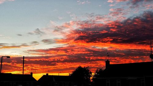 Low angle view of silhouette building against sunset sky