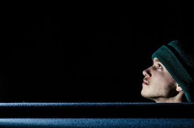 Close-up of young man against black background