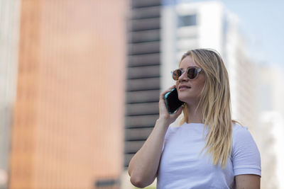 Woman using smartphone at day time with city view landscape . mobile phone, technology, urban.