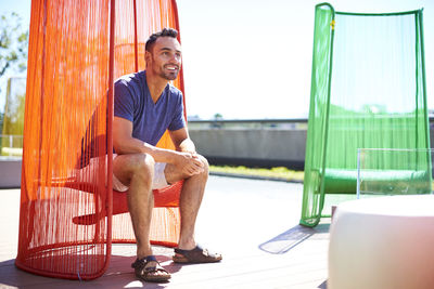 A man sitting in a colorful modern chair.