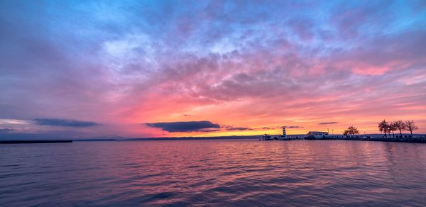 Scenic view of sea against dramatic sky during sunset