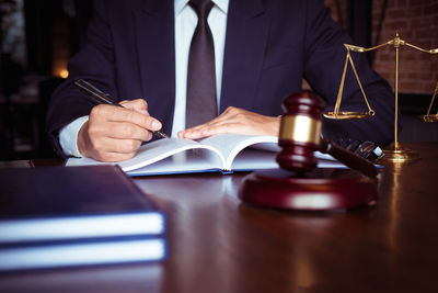 Midsection of man reading book