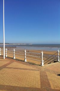 Scenic view of beach against clear blue sky