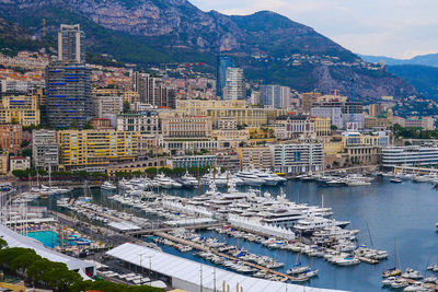 High angle view of city by sea and buildings against sky