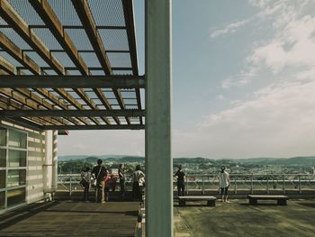 People standing by sea against sky