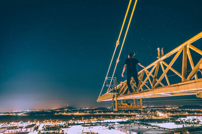 Low angle view of illuminated bridge against sky at night