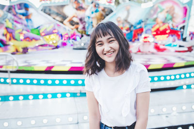 Beautiful asian girl in an amusement park, smiling