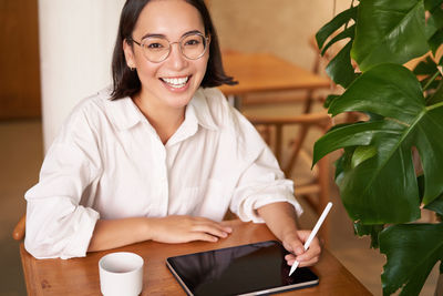 Portrait of young woman using digital tablet