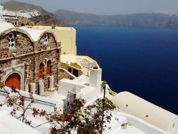 Exterior of building by sea against mountain
