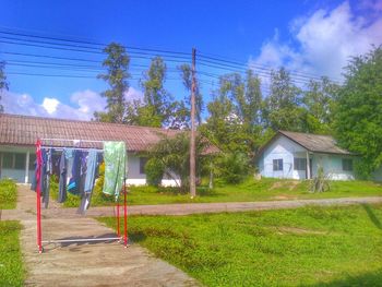 Houses on field against cloudy sky