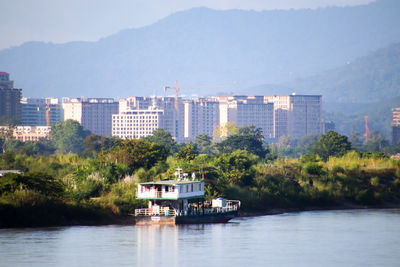 Scenic view of river by city against sky