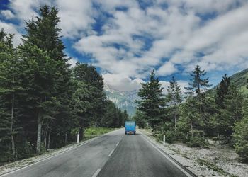 Road amidst trees against sky