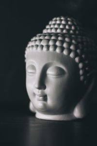 Close-up of buddha statue on table