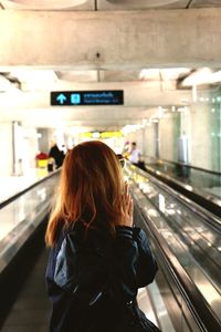 Rear view of woman standing in train