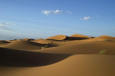 Sand dunes in desert against sky