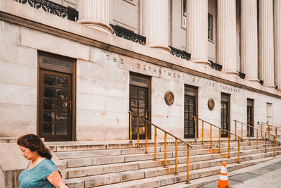 Side view of woman on footpath by building