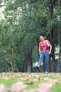 Woman standing by trees against plants