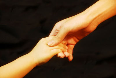 Close-up of woman hands against black background