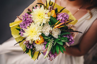 Stylish wedding bouquet bride of pink roses, white carnation and green flowers and greens with 