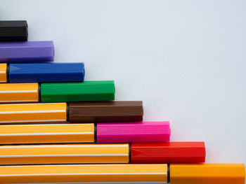 Stack of multi colored pencils on table against white background
