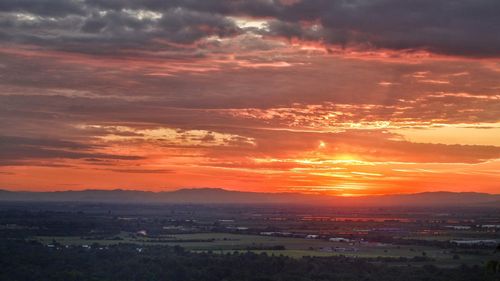 Scenic view of silhouette landscape against orange sky