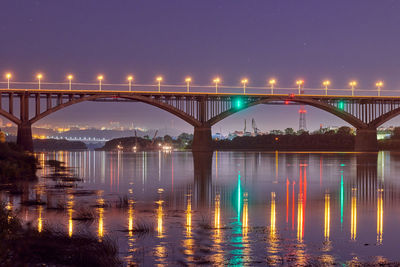 Night city bridge lighting. beautiful reflection of night lights on water surface. long exposure