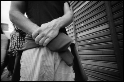 Midsection of woman holding hands while sitting on floor