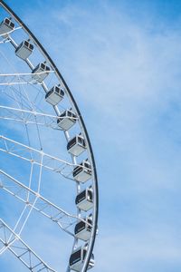 Low angle view of ferris wheel against blue sky