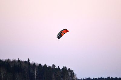 Low angle view of person paragliding against sky