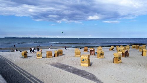 Panoramic view of seagulls on beach against sky