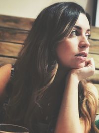 Thoughtful woman looking away while sitting in cafe