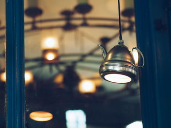 Close-up of illuminated pendant light hanging in darkroom