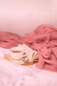 Close-up of coffee cup on bed