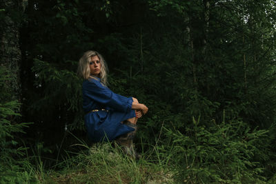 Girl in a blue dress on the background of the forest