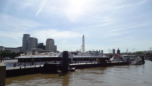Harbor by river against sky in city
