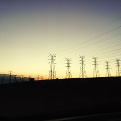 Electricity pylon against sky at sunset