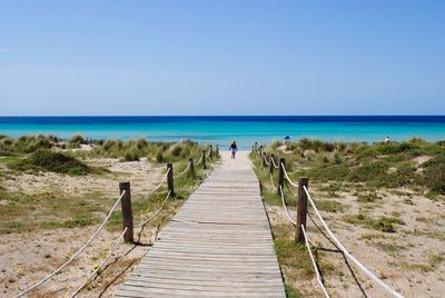 Boardwalk leading towards beach against sky