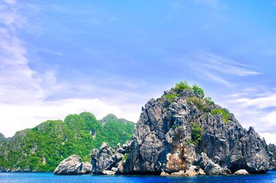 Rock formation by sea against sky