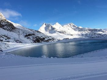 Scenic view of snowcapped mountains against blue sky