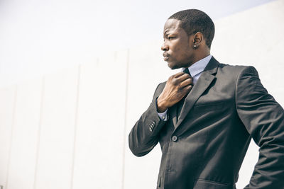 Man looking away against wall