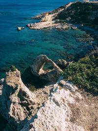 High angle view of rock formation in sea against sky